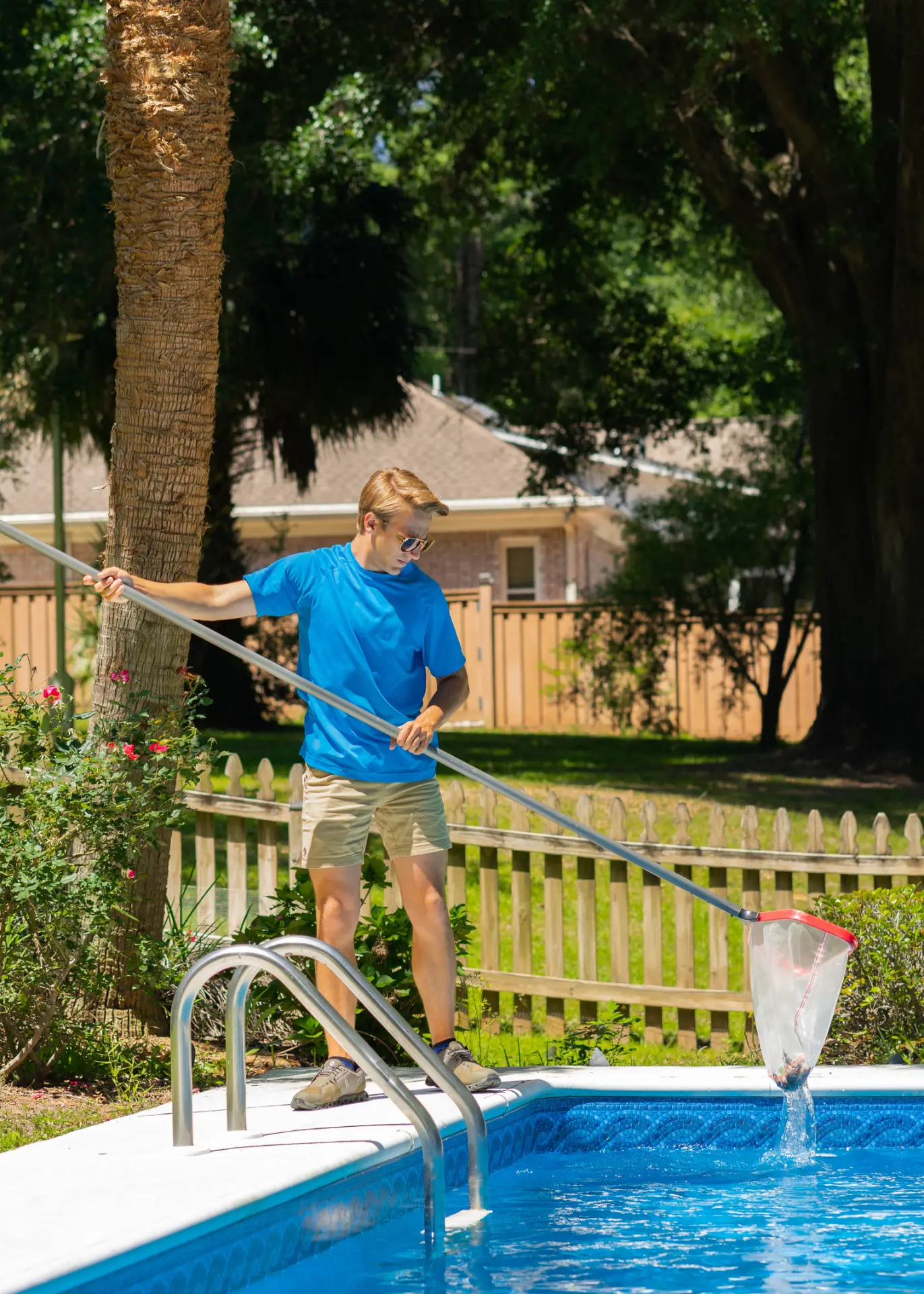 Technician skimming leaves from a pool