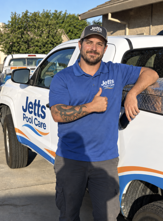 Jeremy from Jetts Pool Care giving a thumbs up by a branded service truck